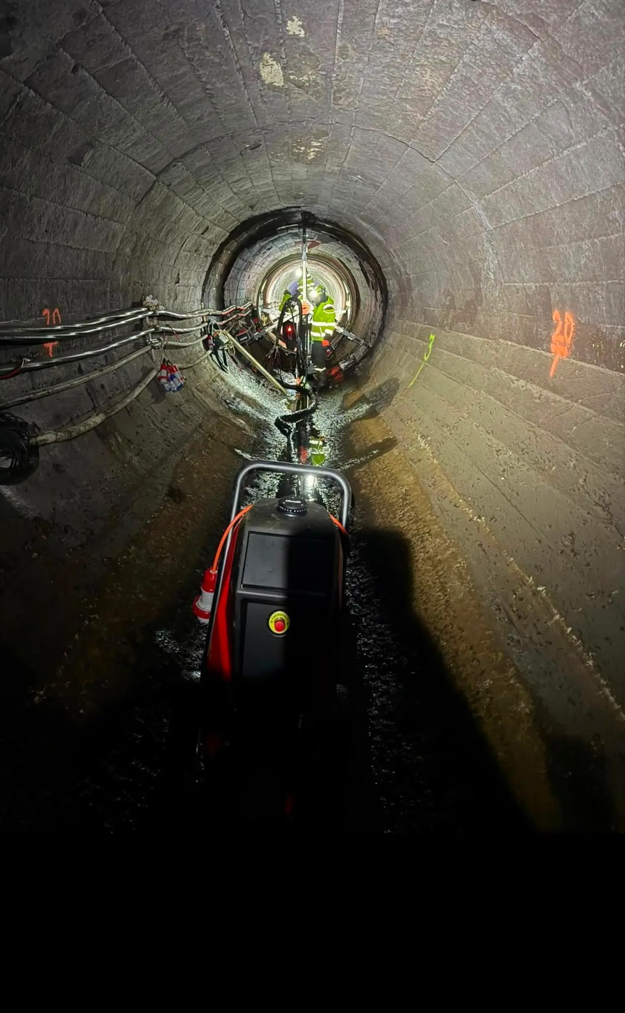 Tunnel indefra med arbejdslys og udstyr på bunden.
